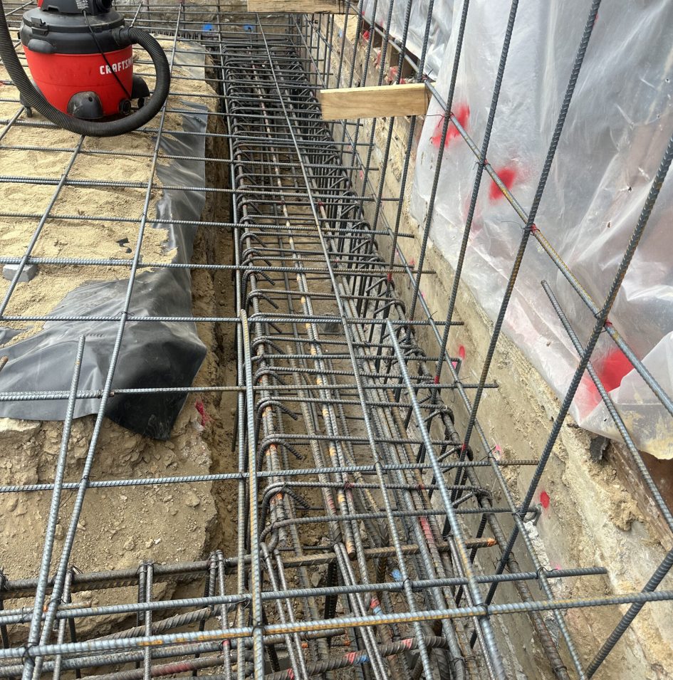 Construction site with rebar and vacuum cleaner.